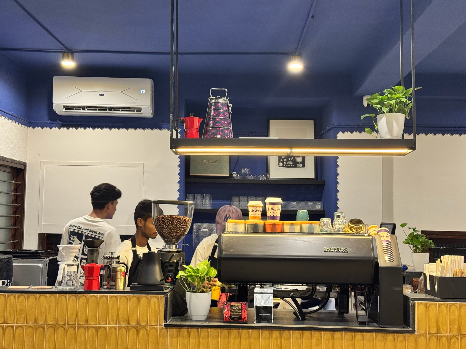 Gulabo & Co. cafe counter with espresso machine, coffee grinders and warm lighting