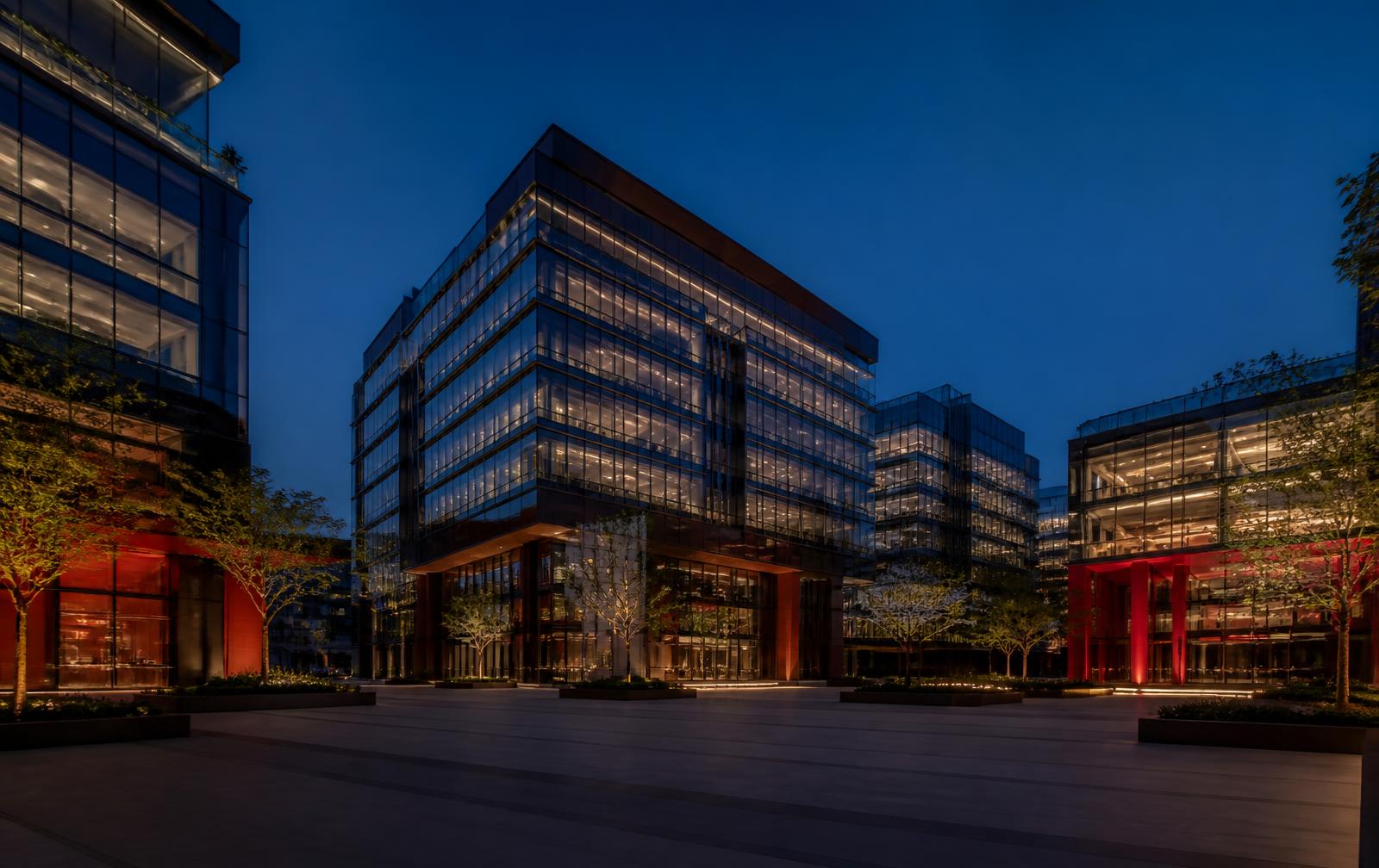 Premium glass commercial office campus illuminated at blue hour